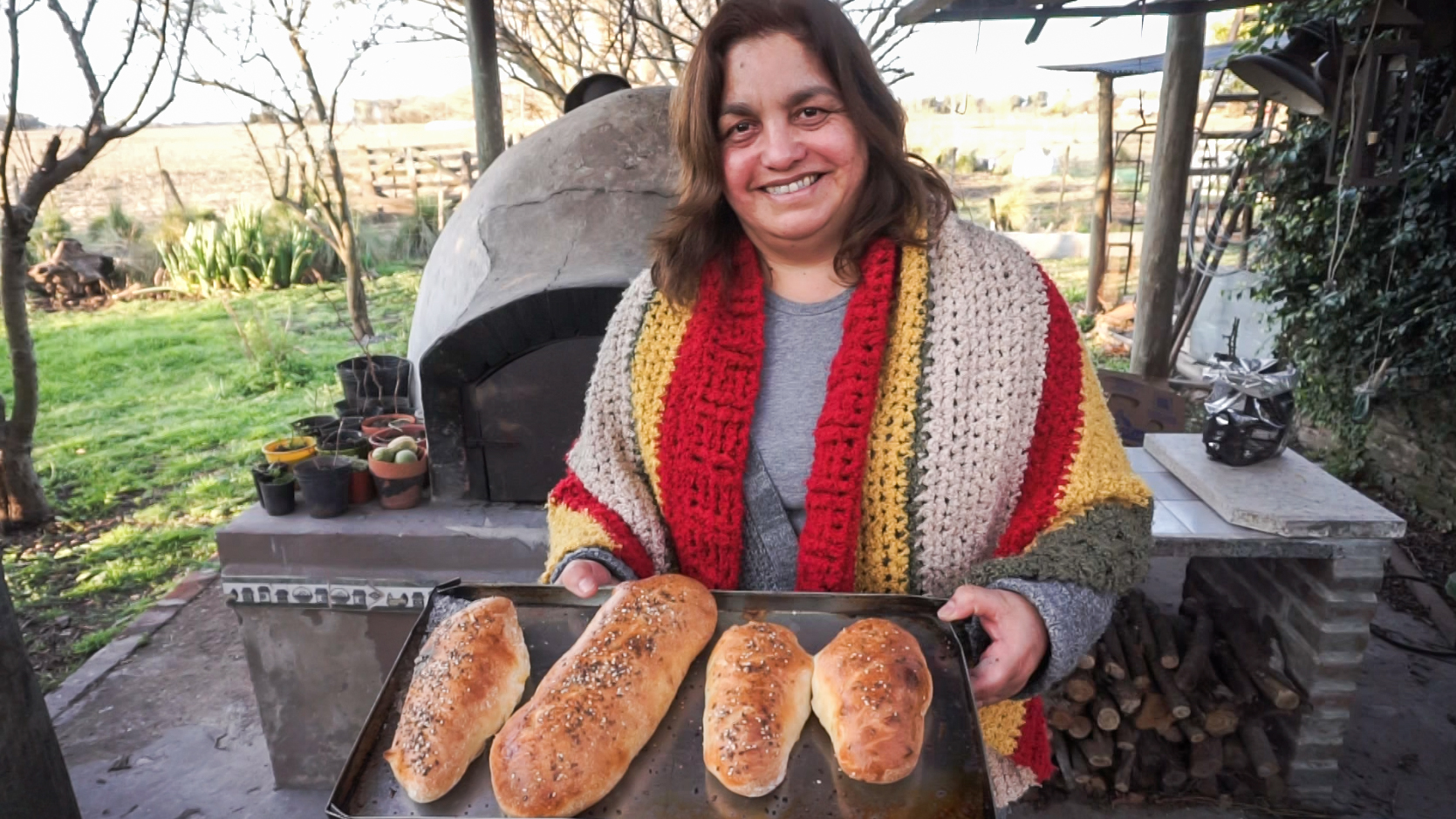 Clide sacando panes del horno de barro